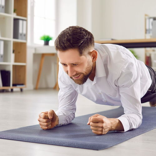 Ein Patient vollzieht präventives Training des Rückenbereiches auf einer Trainingsmatte.